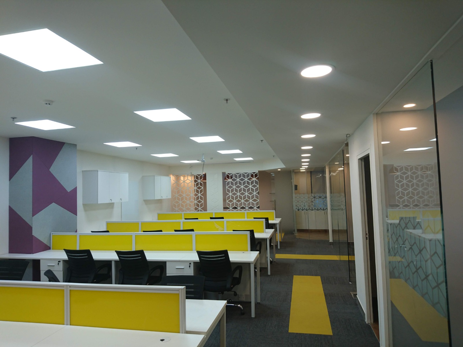 Fitted open workstation area with yellow dividers at the Iris Tech Park office